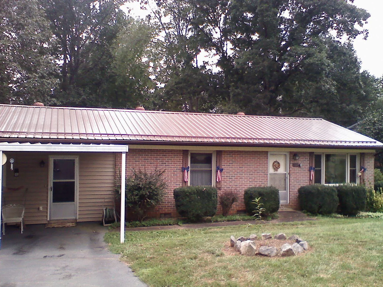 Bronze metal roof and carport on a brick ranch home — Roof Repair work by our crew in Vermillion